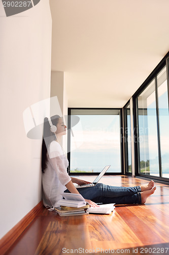 Image of relaxed young woman at home working on laptop