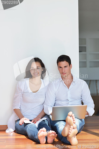 Image of relaxed young couple working on laptop computer at home