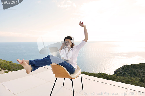 Image of relaxed young woman at home working on laptop