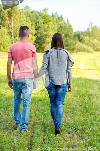 Image of Rear view of young couple walking outdoor