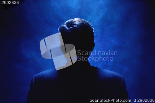 Image of Silhouette of man bathed in blue light.