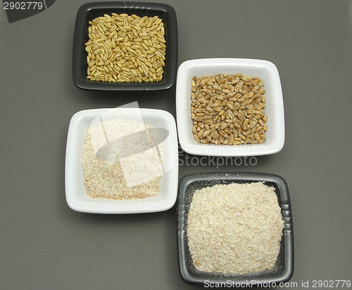 Image of Bowls of chinaware with cereal and wholemeal on gray matting