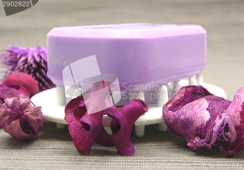 Image of Lilac soap with decoration articles on a  gray background