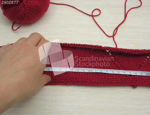 Image of Red knitting with whole pattern and measuring tape