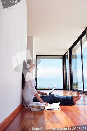 Image of relaxed young woman at home working on laptop