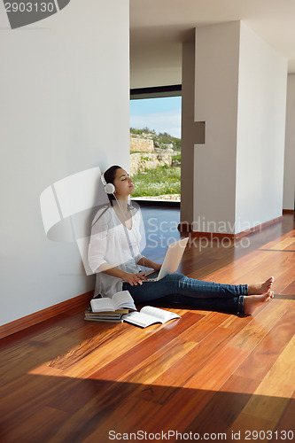 Image of relaxed young woman at home working on laptop