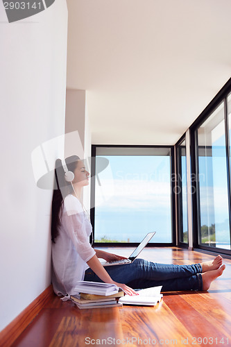 Image of relaxed young woman at home working on laptop