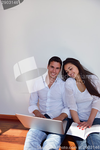 Image of relaxed young couple working on laptop computer at home