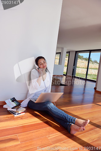 Image of relaxed young woman at home working on laptop