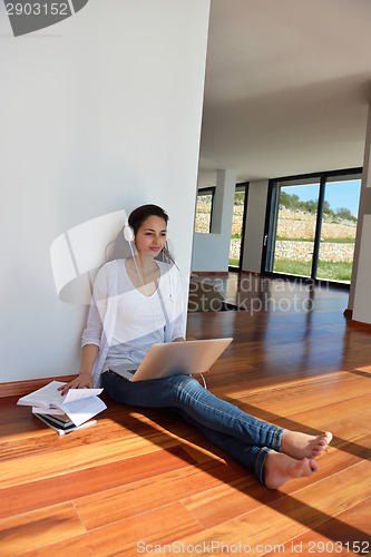 Image of relaxed young woman at home working on laptop