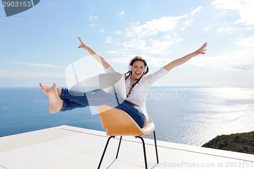 Image of relaxed young woman at home working on laptop