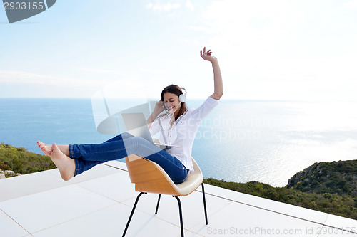 Image of relaxed young woman at home working on laptop