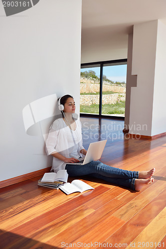 Image of relaxed young woman at home working on laptop