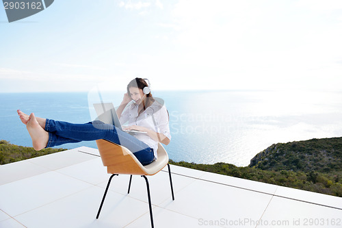 Image of relaxed young woman at home working on laptop