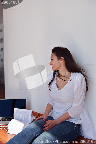 Image of relaxed young woman at home working on laptop