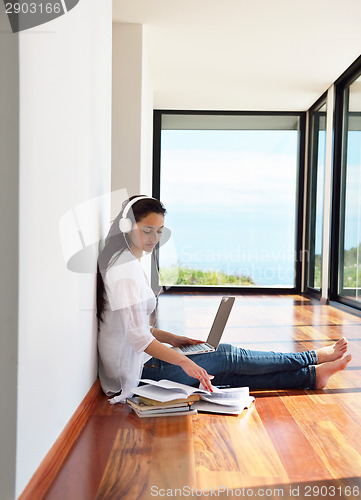 Image of relaxed young woman at home working on laptop