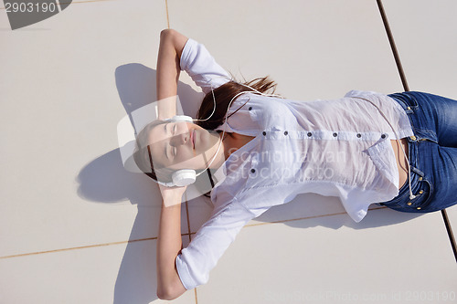 Image of girl listening to the music on white headphones