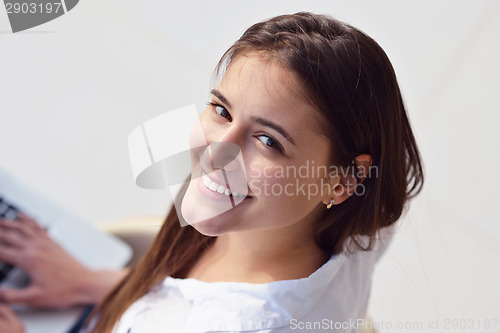 Image of relaxed young woman at home working on laptop computer