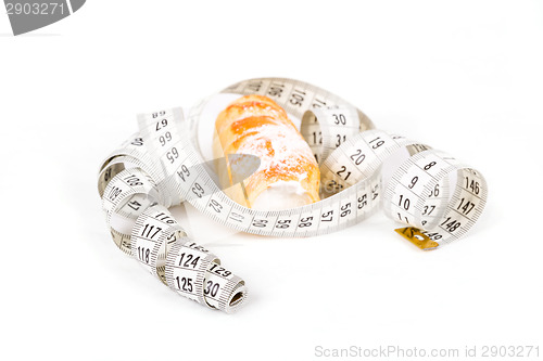 Image of concept of slimming, cakes with measuring tape