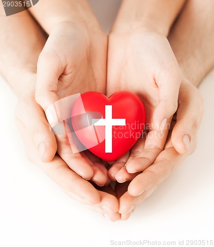 Image of couple hands holding heart with cross symbol