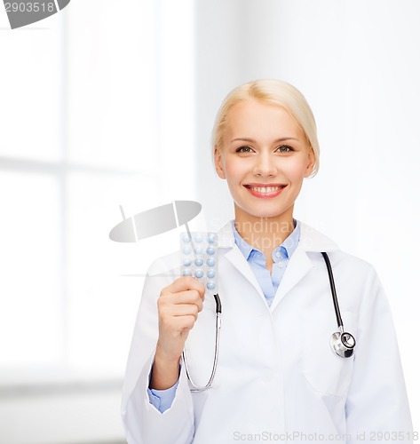 Image of smiling female doctor with pills