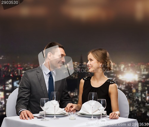 Image of smiling couple looking at each other at restaurant