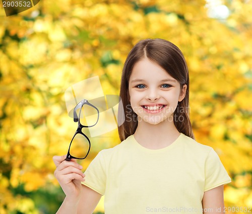 Image of smiling cute little girl holding black eyeglasses