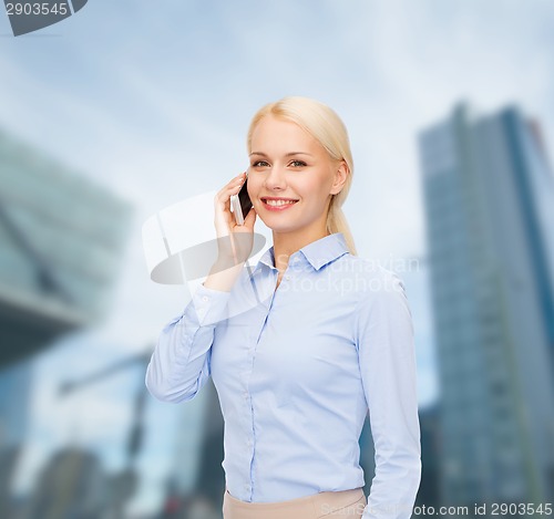 Image of young smiling businesswoman with smartphone