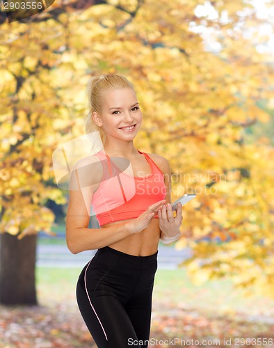 Image of smiling sporty woman with smartphone