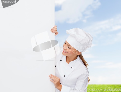 Image of smiling female chef with white blank board