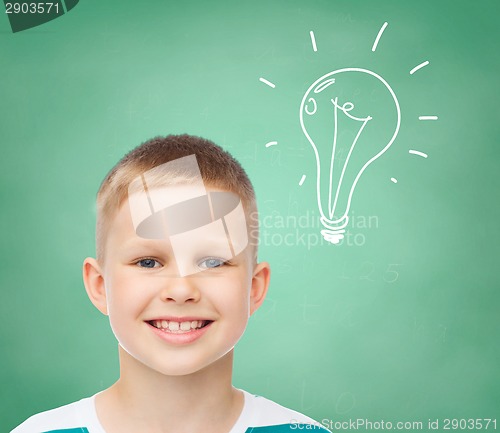 Image of smiling little boy over green board background