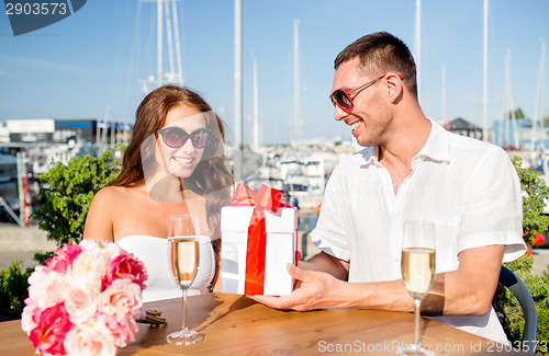 Image of smiling couple with gift box cafe