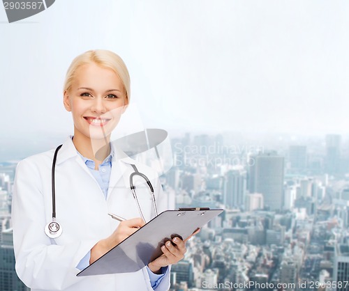 Image of smiling female doctor with clipboard