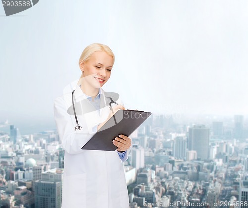 Image of smiling female doctor with clipboard