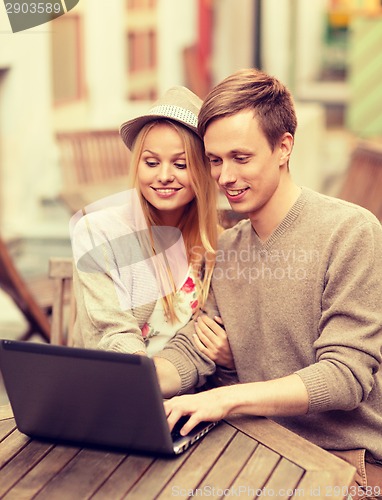 Image of couple with laptop in cafe