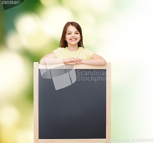 Image of happy little girl with blank blackboard