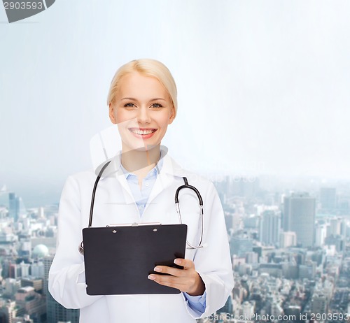 Image of smiling female doctor with clipboard