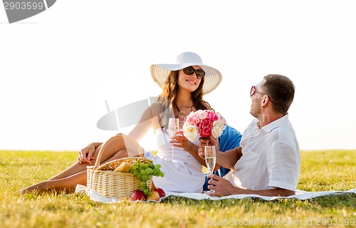 Image of smiling couple drinking champagne on picnic