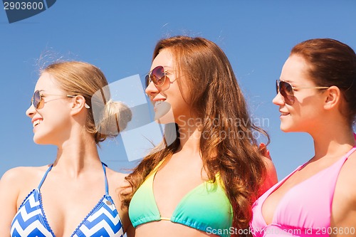 Image of group of smiling young women on beach