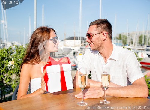 Image of smiling couple with gift box cafe