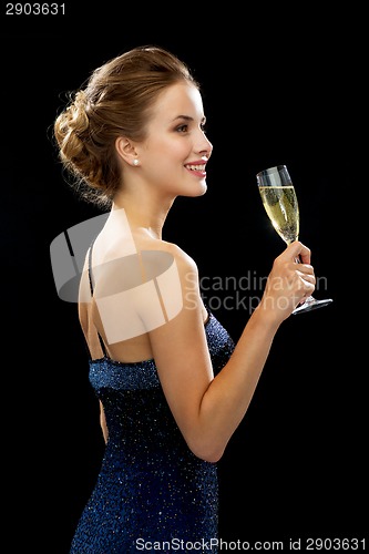 Image of smiling woman holding glass of sparkling wine