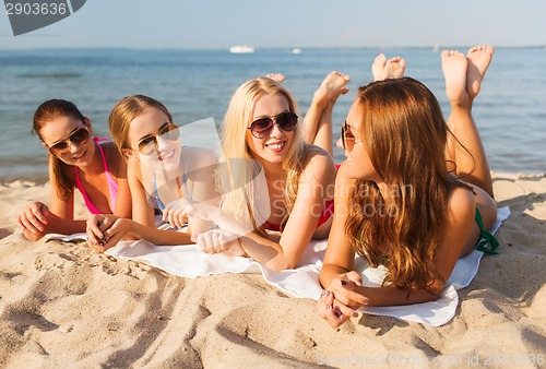 Image of group of smiling women in sunglasses on beach