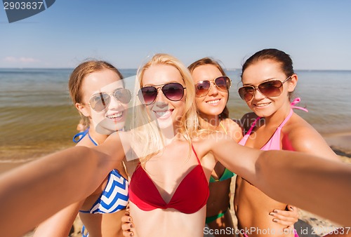 Image of group of young smiling women making selfie