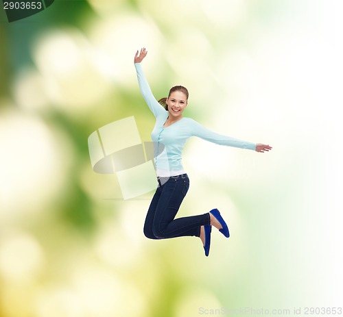 Image of smiling young woman jumping in air