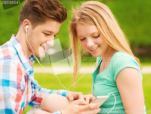 Image of smiling couple with smartphone and earphones