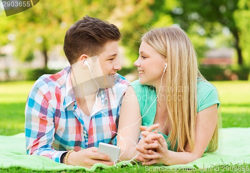 Image of smiling couple with smartphone and earphones