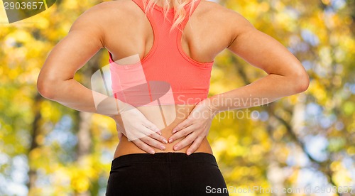 Image of close up of sporty woman touching her back