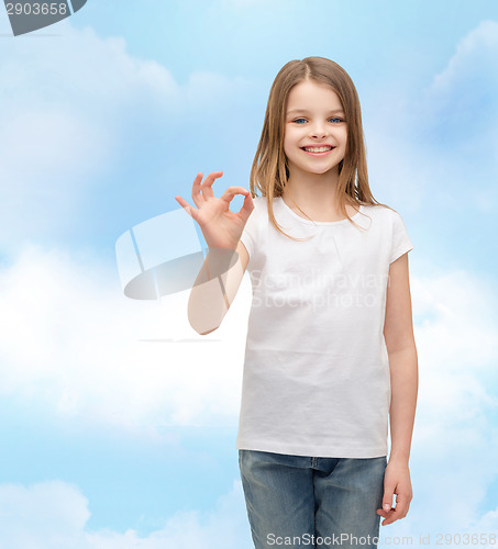 Image of little girl in white t-shirt showing ok gesture