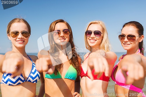 Image of group of smiling young women on beach