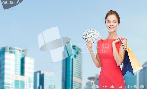 Image of smiling woman in red dress with shopping bags